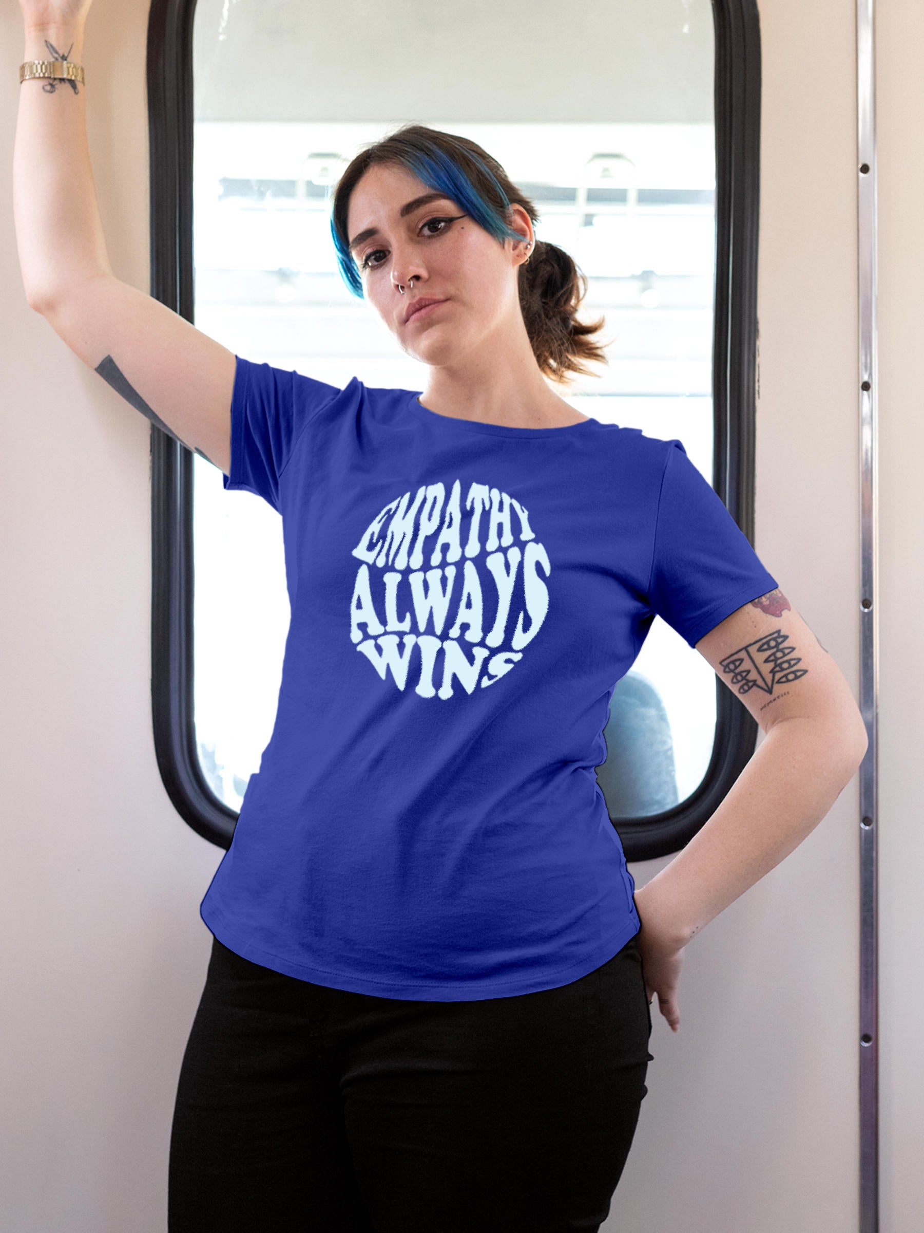 Model wearing Women's Blue Round Neck T-shirt with 'Empathy Always Wins' design, offering effortless style and premium comfort