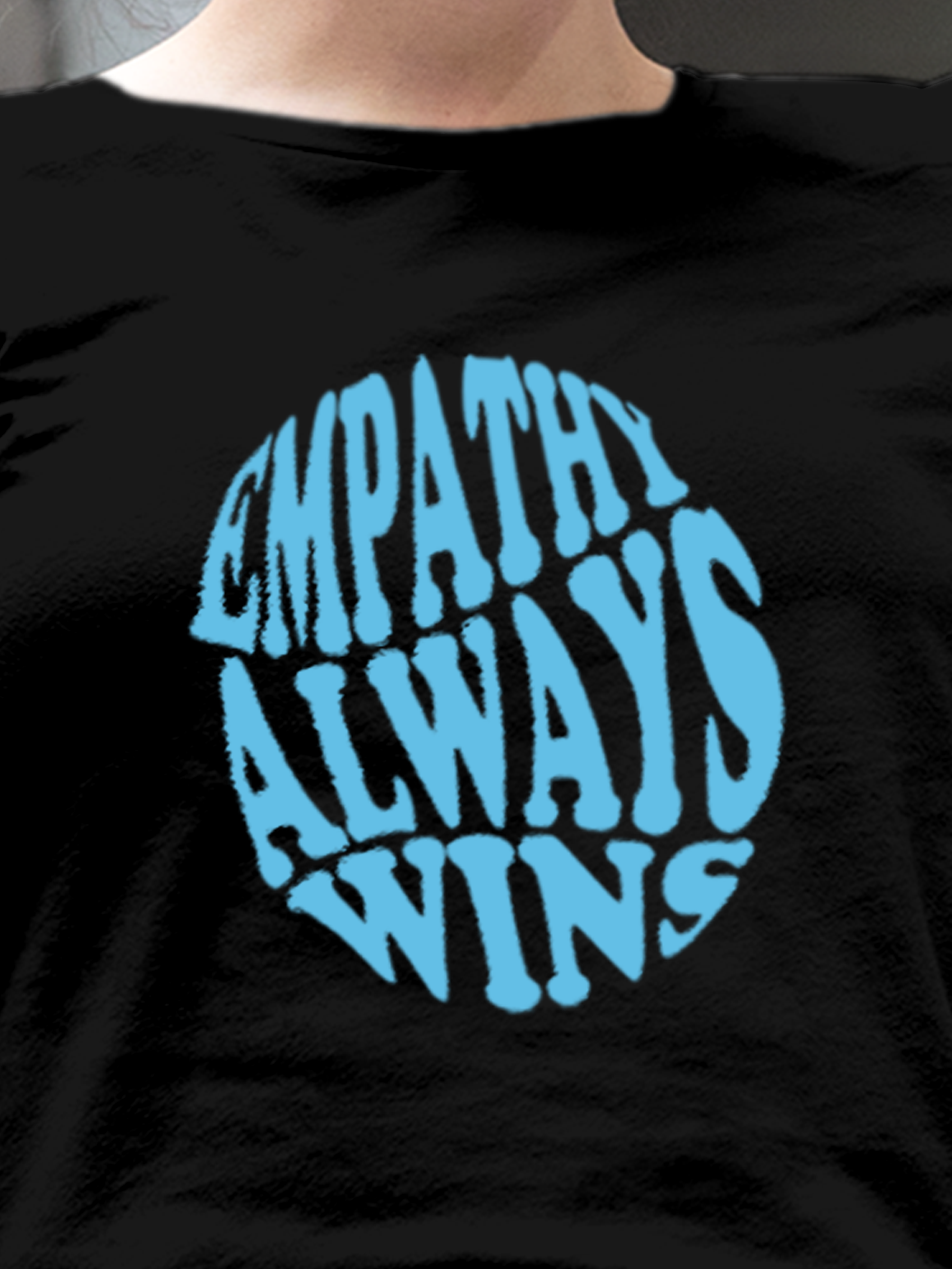 Close up of 'Empathy Always Wins' design on Women's Black Round Neck T-shirt, highlighting intricate details and vibrant print.