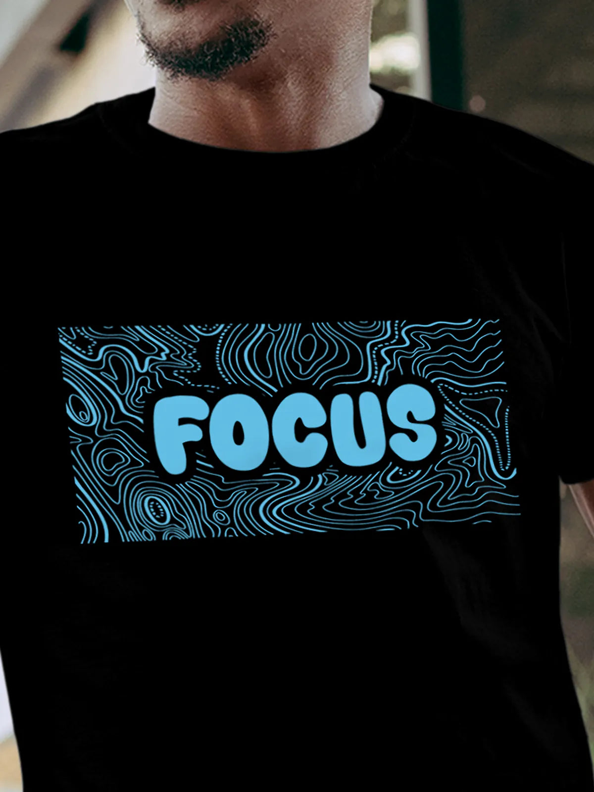 Close up of 'Focus In Chaos' design on Men's Black Round Neck T-shirt, highlighting intricate details and vibrant print.