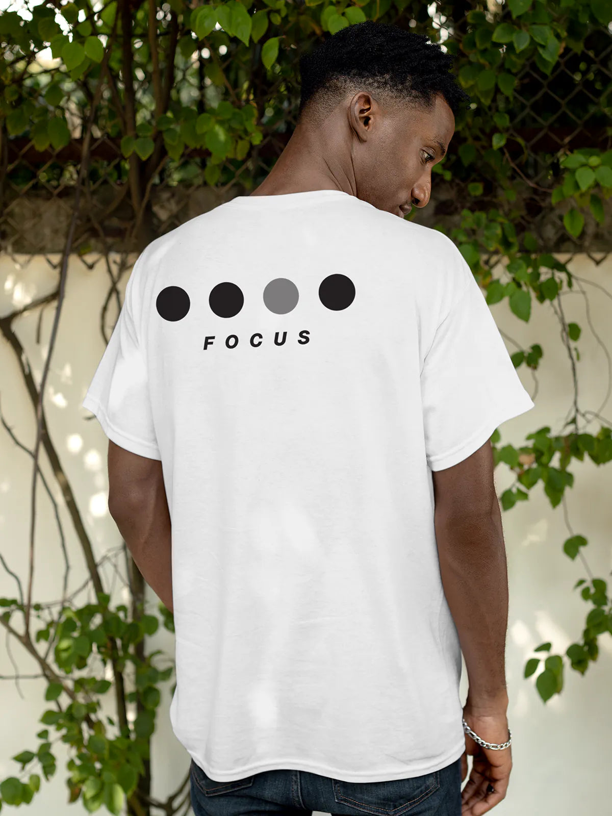 Model wearing Men's White Round Neck T-shirt with 'Focus On Goal' design, offering effortless style and premium comfort