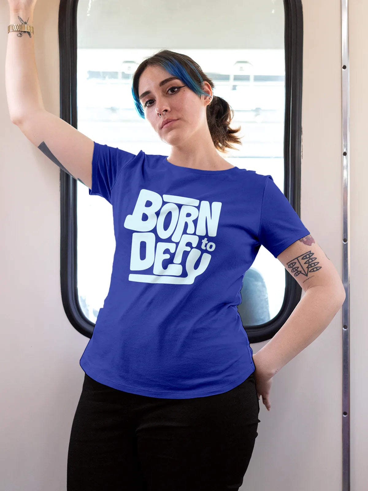 Model wearing Women's Blue Round Neck T-shirt with 'Born To Defy' design, offering effortless style and premium comfort