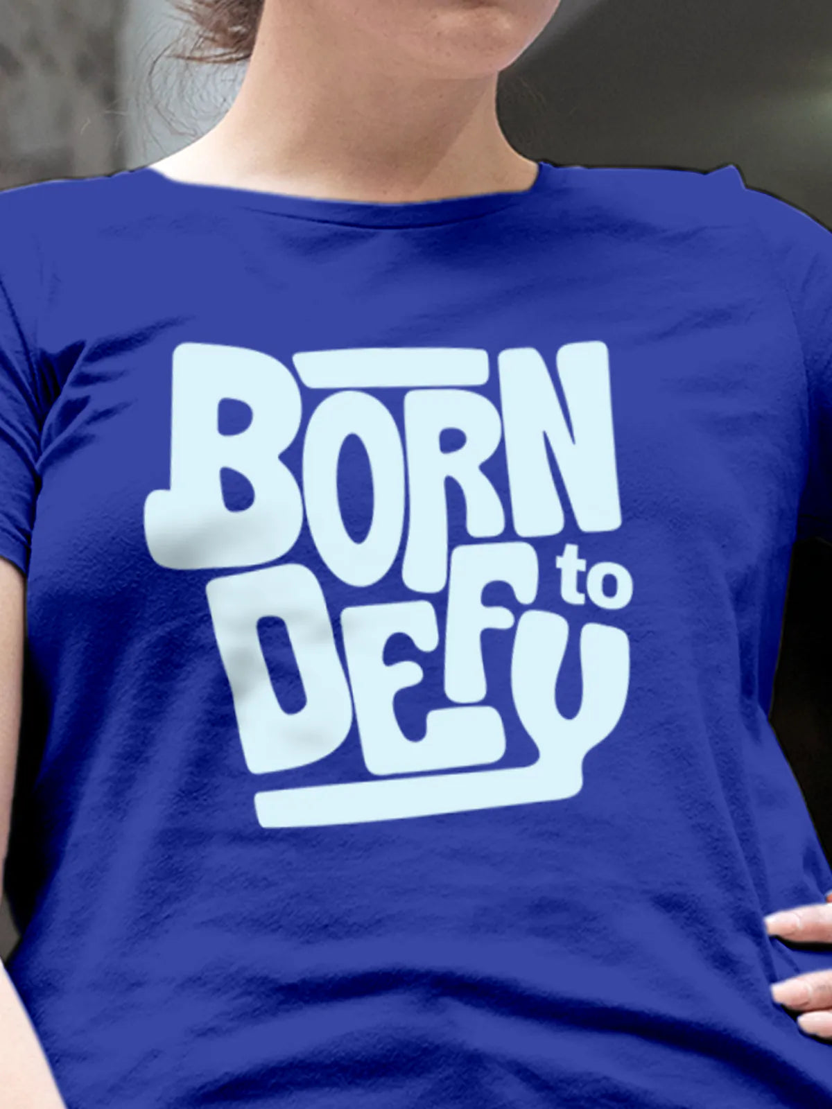 Close up of 'Born To Defy' design on Women's Blue Round Neck T-shirt, highlighting intricate details and vibrant print.