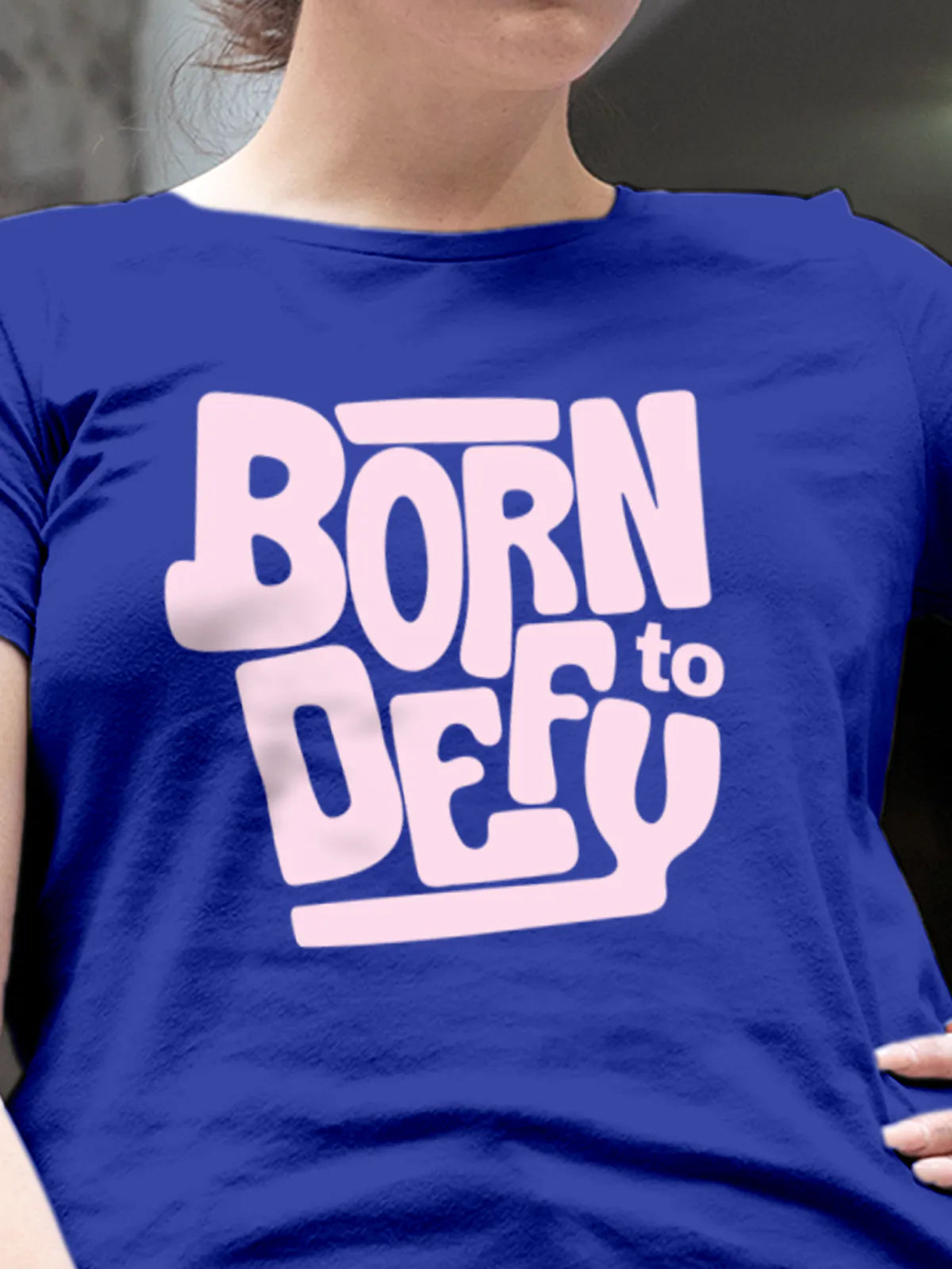Close up of 'Born To Defy' design on Women's Blue Round Neck T-shirt, highlighting intricate details and vibrant print.