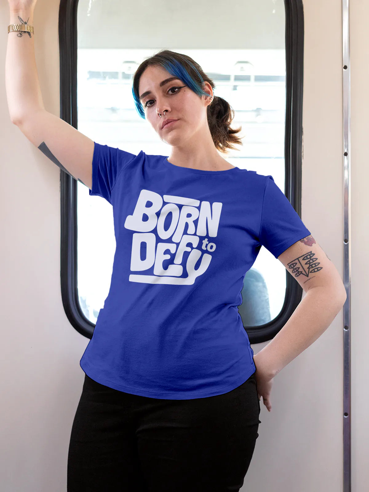 Model wearing Women's Blue Round Neck T-shirt with 'Born To Defy' design, offering effortless style and premium comfort