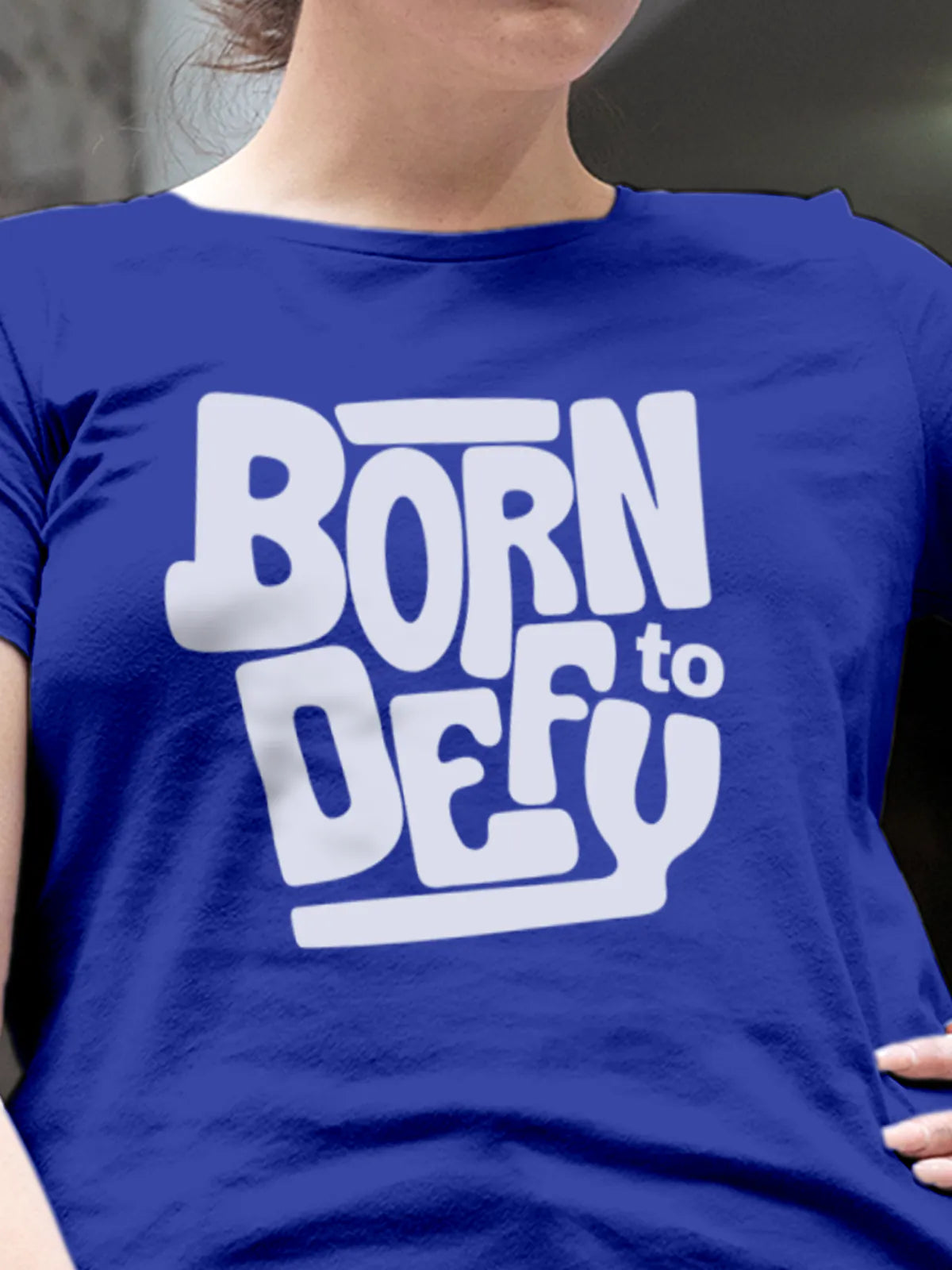 Close up of 'Born To Defy' design on Women's Blue Round Neck T-shirt, highlighting intricate details and vibrant print.