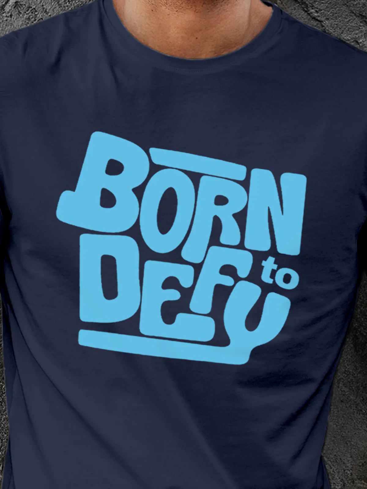 Close up of 'Born To Defy' design on Men's Navy Blue Round Neck T-shirt, highlighting intricate details and vibrant print.