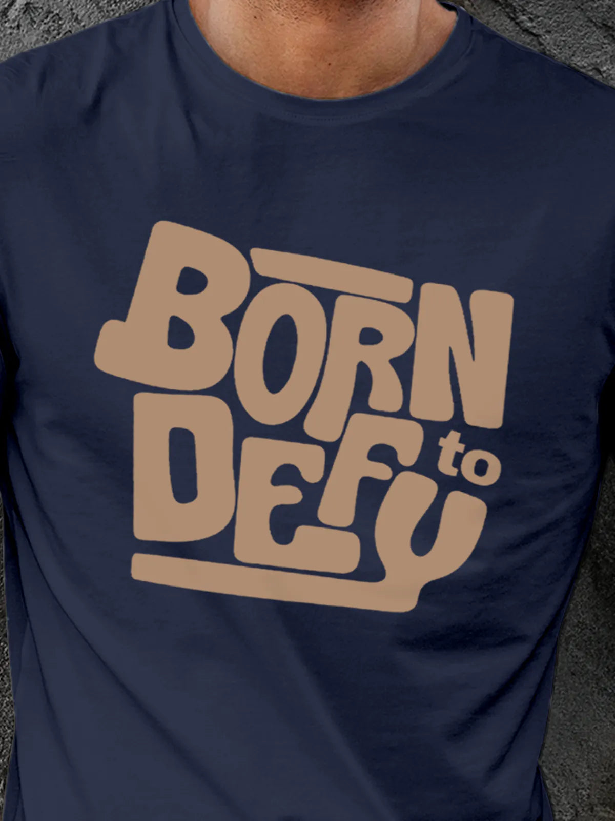 Close up of 'Born To Defy' design on Men's Navy Blue Round Neck T-shirt, highlighting intricate details and vibrant print.