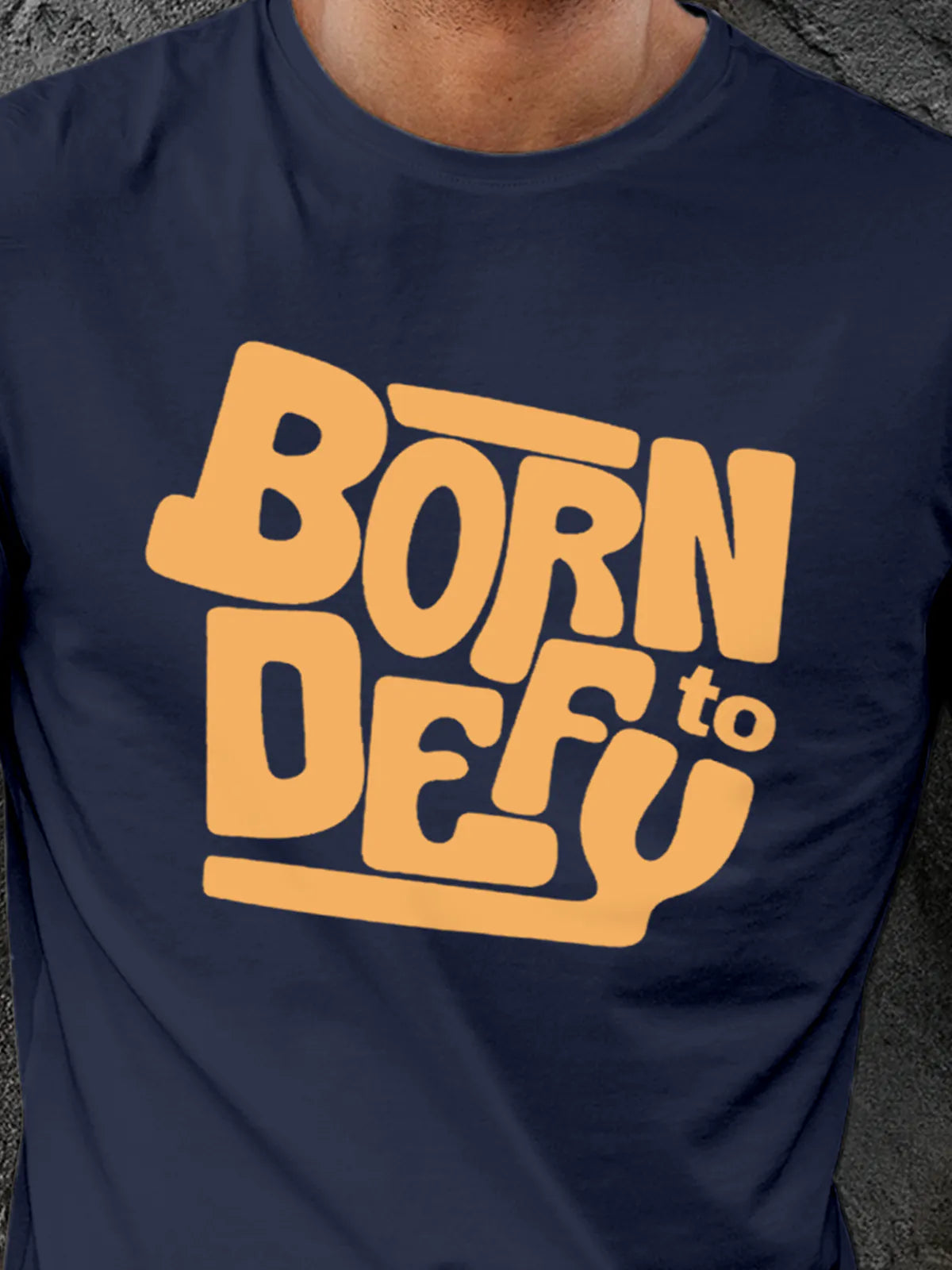 Close up of 'Born To Defy' design on Men's Navy Blue Round Neck T-shirt, highlighting intricate details and vibrant print.