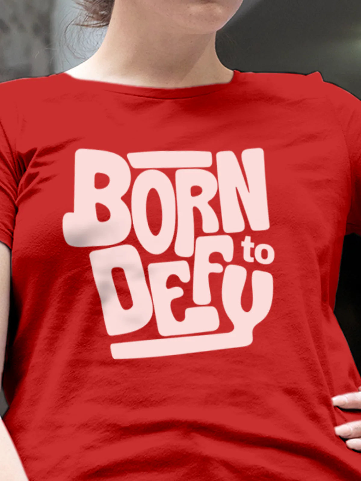 Close up of 'Born To Defy' design on Women's Red Round Neck T-shirt, highlighting intricate details and vibrant print.