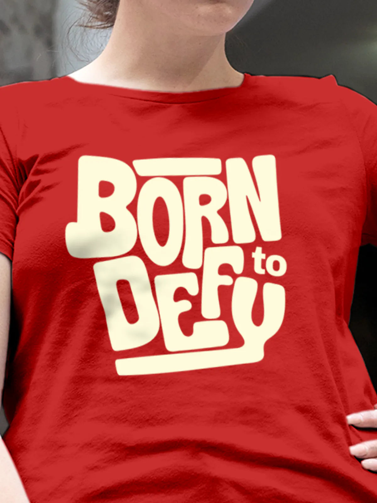 Close up of 'Born To Defy' design on Women's Red Round Neck T-shirt, highlighting intricate details and vibrant print.
