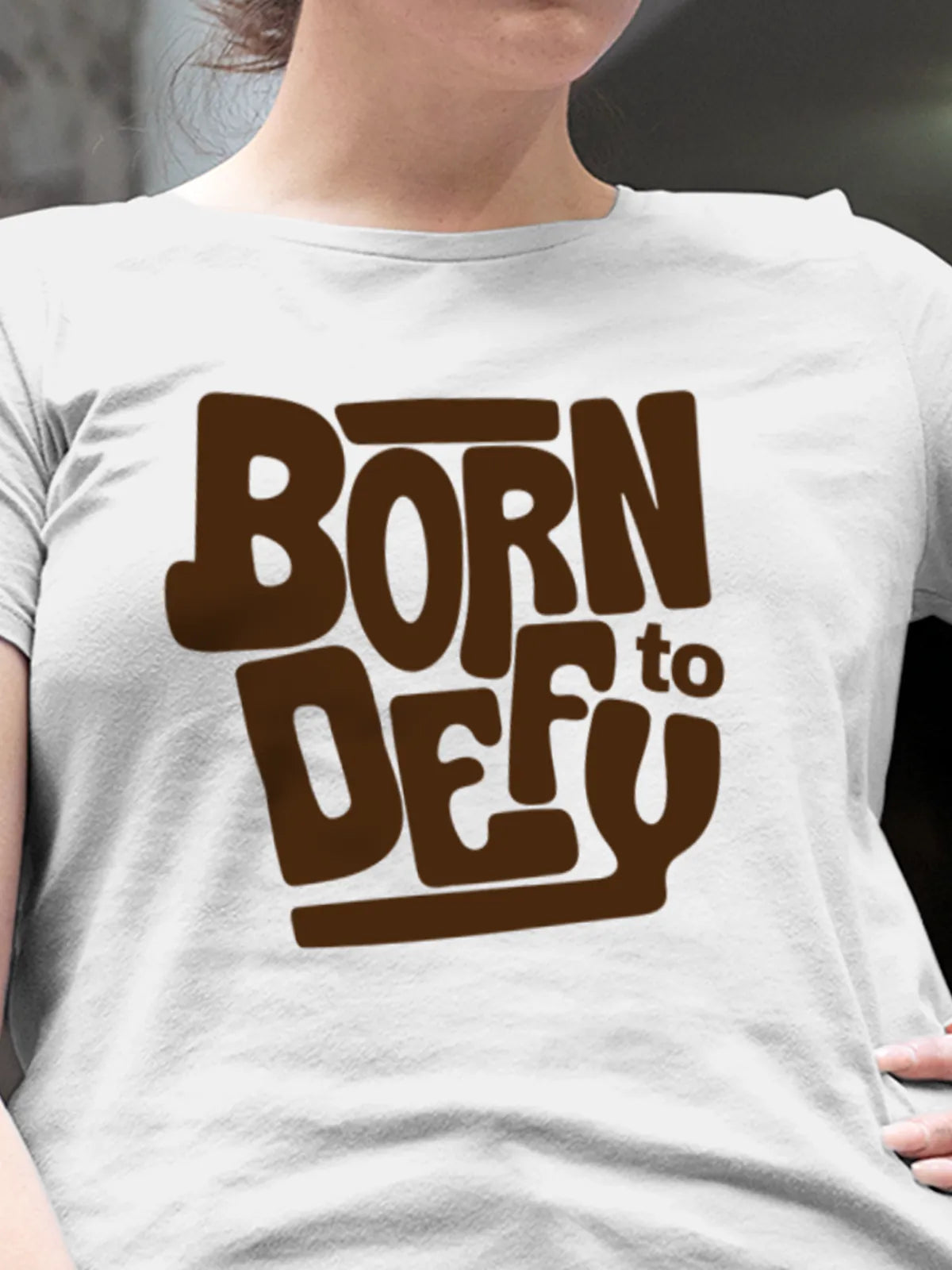 Close up of 'Born To Defy' design on Women's White Round Neck T-shirt, highlighting intricate details and vibrant print.