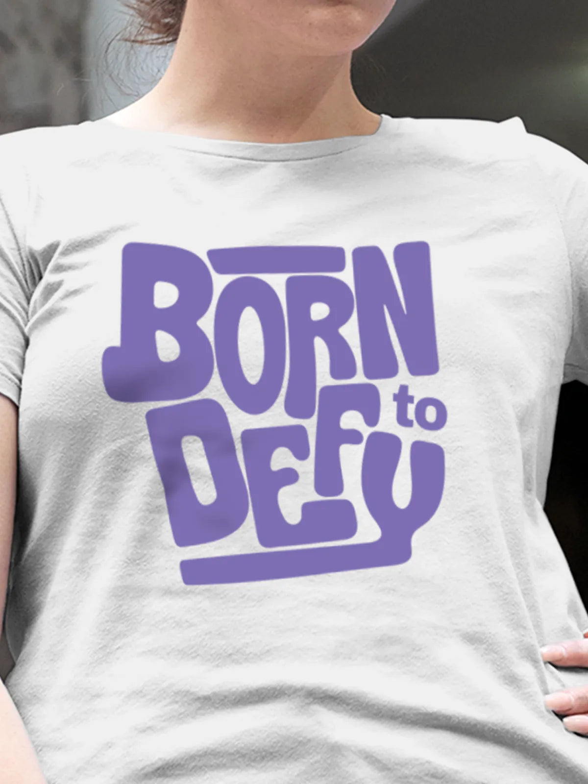 Close up of 'Born To Defy' design on Women's White Round Neck T-shirt, highlighting intricate details and vibrant print.