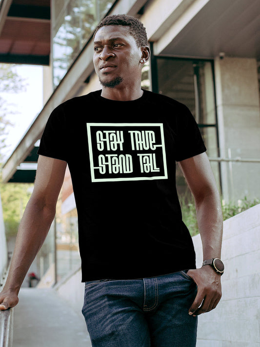 Model wearing Men's Black Round Neck T-shirt with 'Stay True Stand Tall' design, offering effortless style and premium comfort