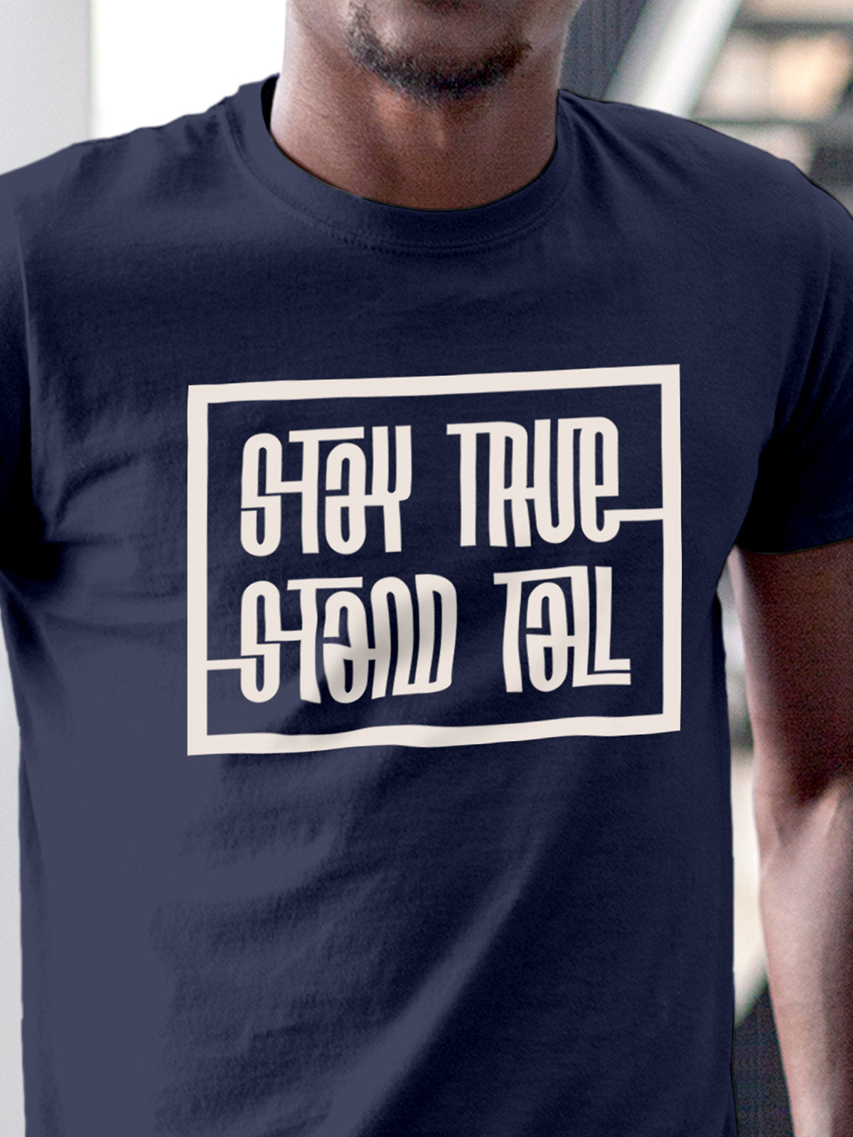 Close up of 'Stay True Stand Tall' design on Men's Navy Blue Round Neck T-shirt, highlighting intricate details and vibrant print.