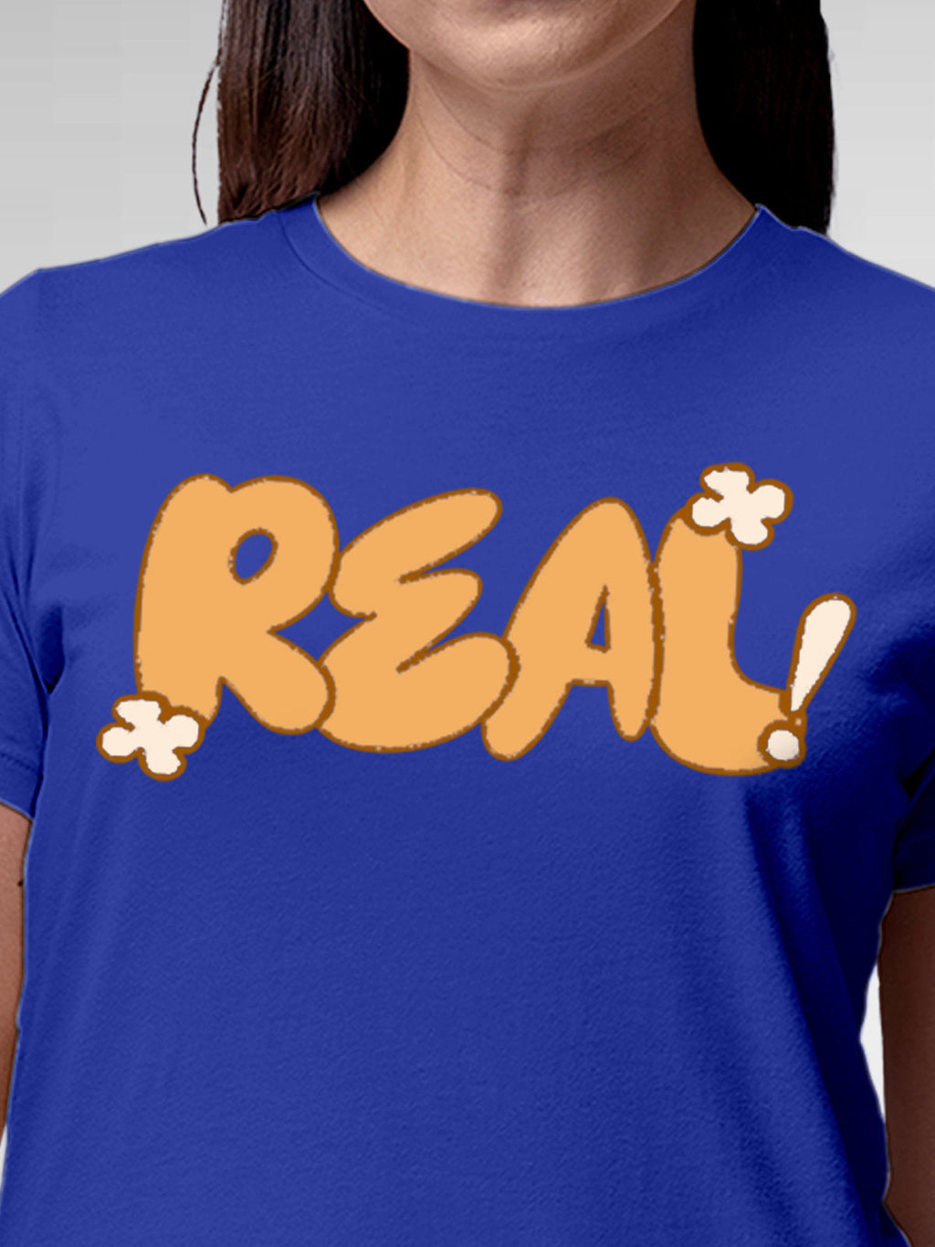 Close up of 'Real' design on Women's Blue Round Neck T-shirt, highlighting intricate details and vibrant print.