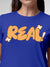 Close up of 'Real' design on Women's Blue Round Neck T-shirt, highlighting intricate details and vibrant print.