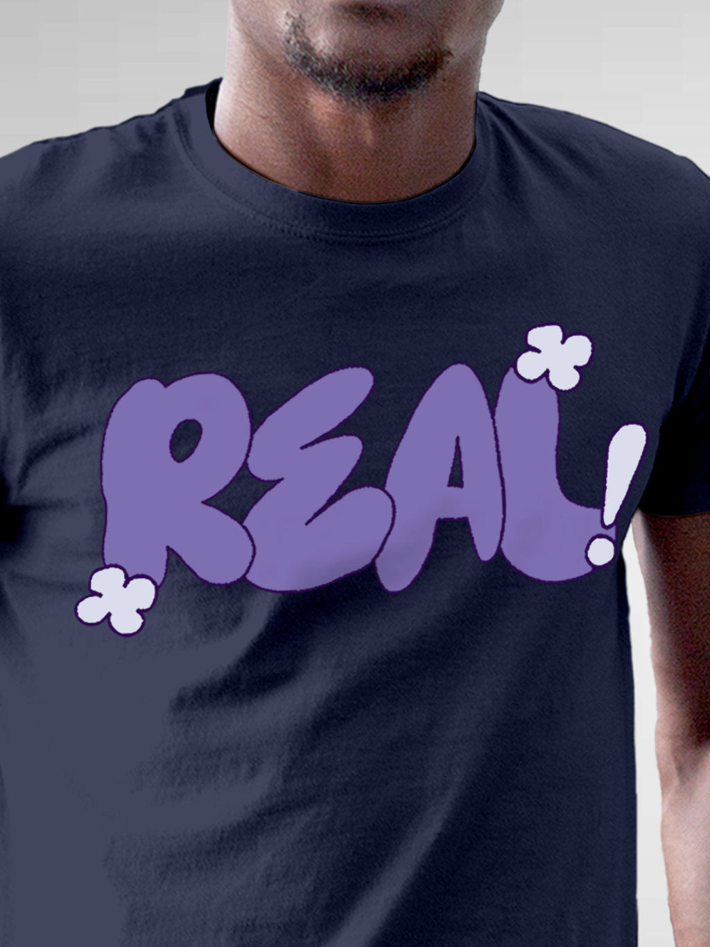 Close up of 'Real' design on Men's Navy Blue Round Neck T-shirt, highlighting intricate details and vibrant print.