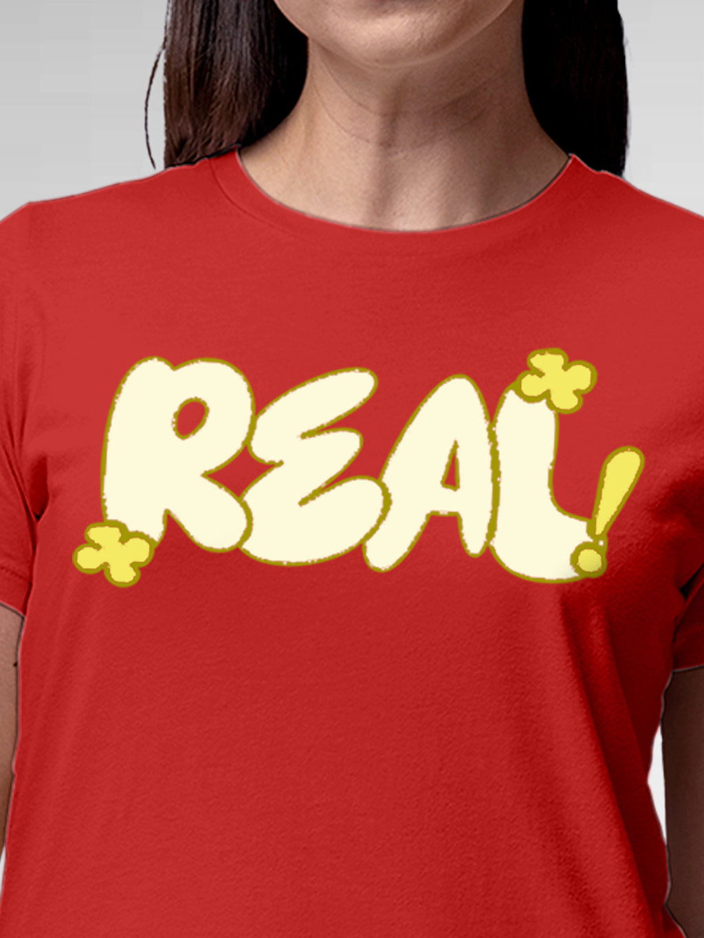 Close up of 'Real' design on Women's Red Round Neck T-shirt, highlighting intricate details and vibrant print.