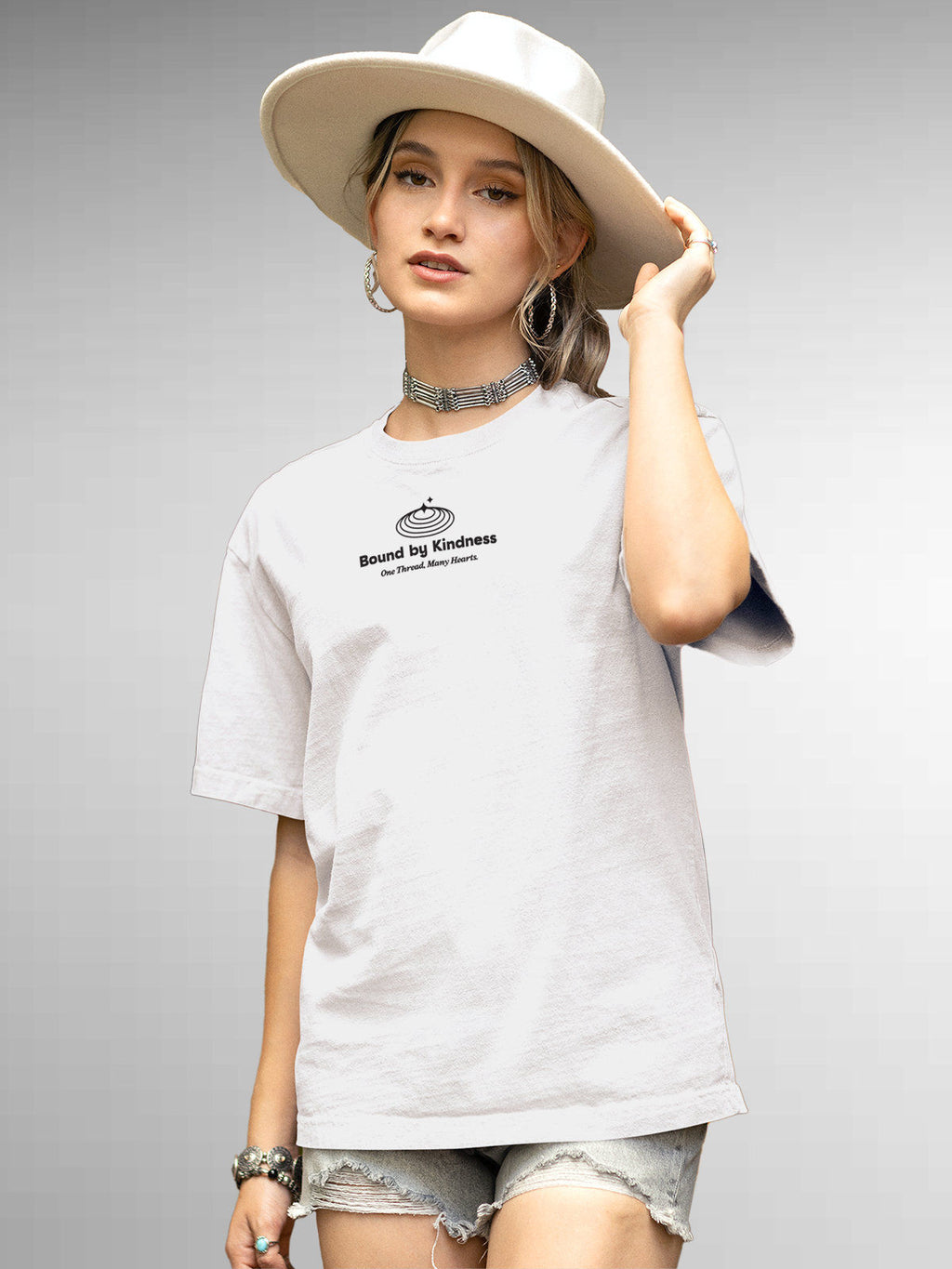 Model wearing Women's White Round Neck T-shirt with 'Bound By Kindness' design, offering effortless style and premium comfort