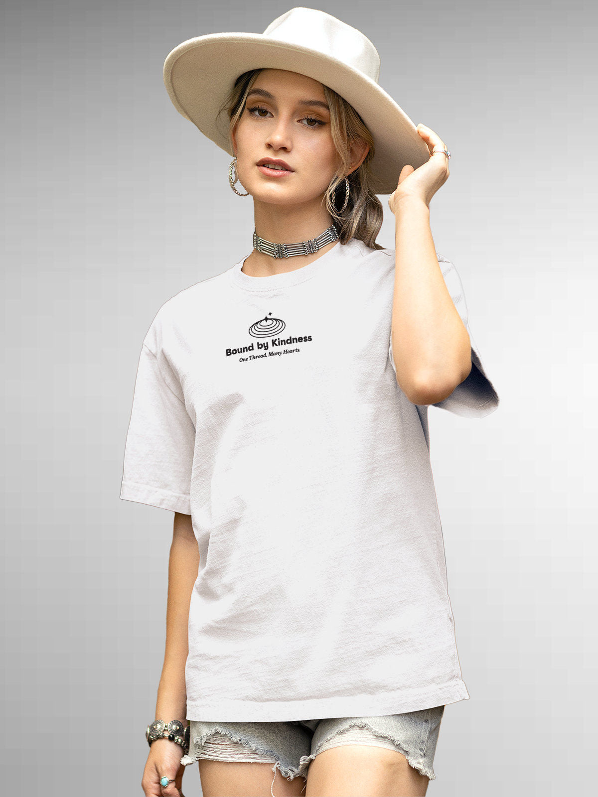 Model wearing Women's White Round Neck T-shirt with 'Bound By Kindness' design, offering effortless style and premium comfort