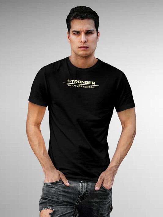 Model wearing Men's Black Round Neck T-shirt with 'Stronger Than Yesterday' design, offering effortless style and premium comfort