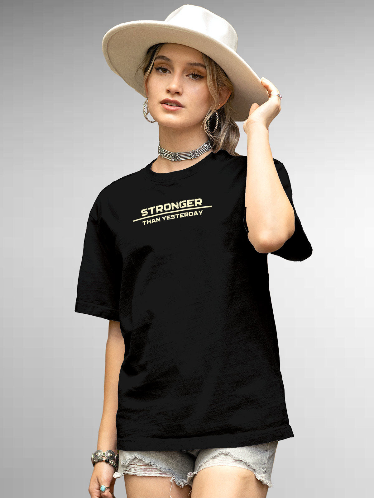 Model wearing Women's Black Round Neck T-shirt with 'Stronger Than Yesterday' design, offering effortless style and premium comfort