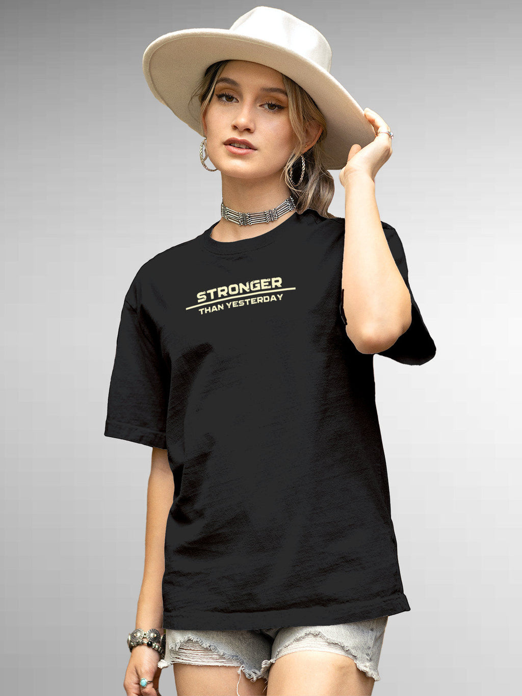 Model wearing Women's Dark Grey Round Neck T-shirt with 'Stronger Than Yesterday' design, offering effortless style and premium comfort
