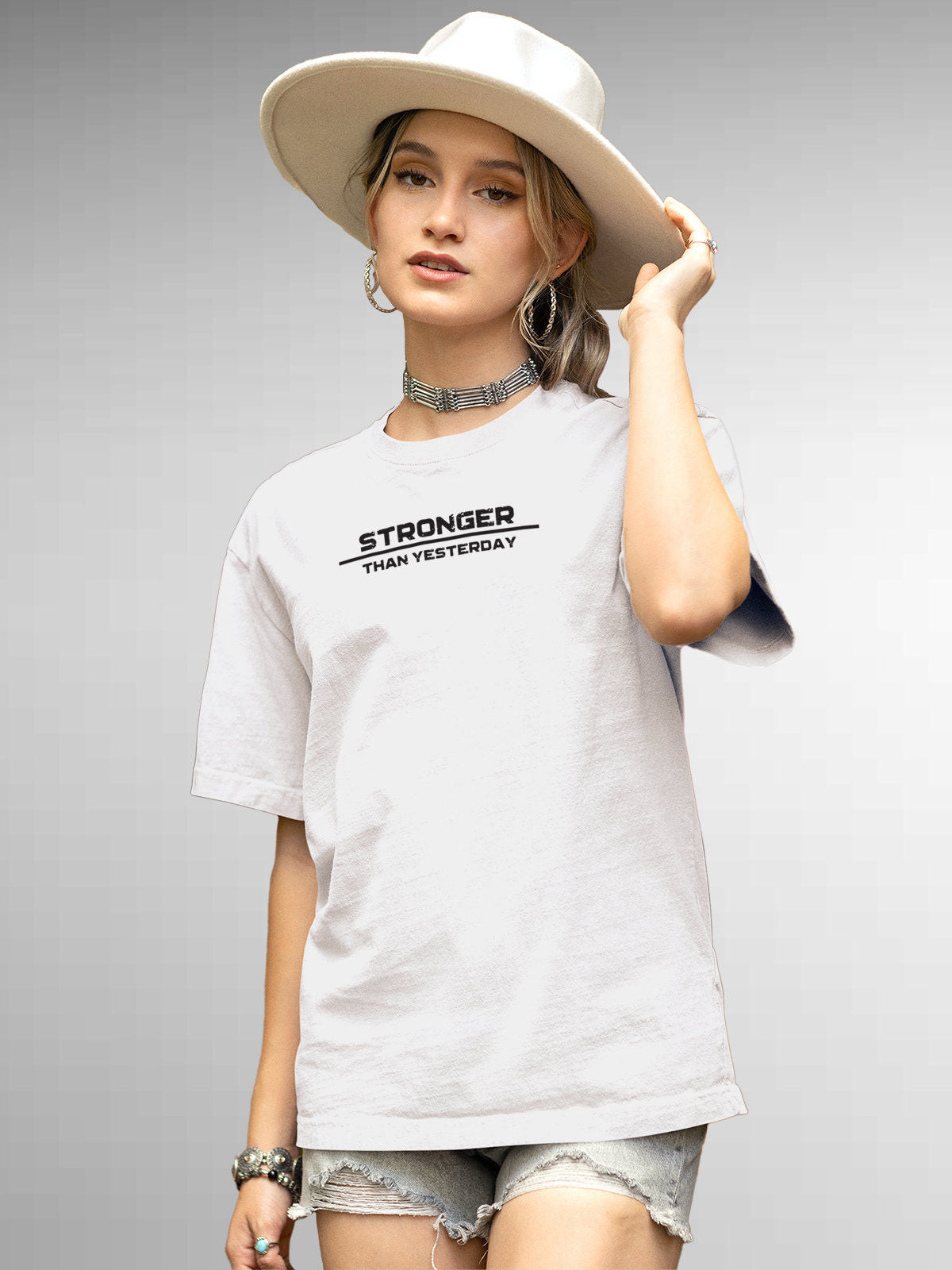 Model wearing Women's White Round Neck T-shirt with 'Stronger Than Yesterday' design, offering effortless style and premium comfort
