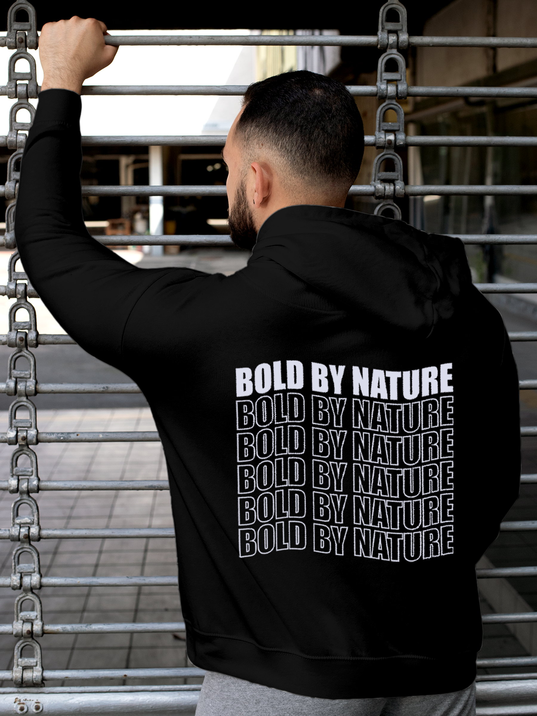 Model wearing Men's Black Hoodie Sweatshirt with 'Bold By Nature' design, offering effortless style and premium comfort