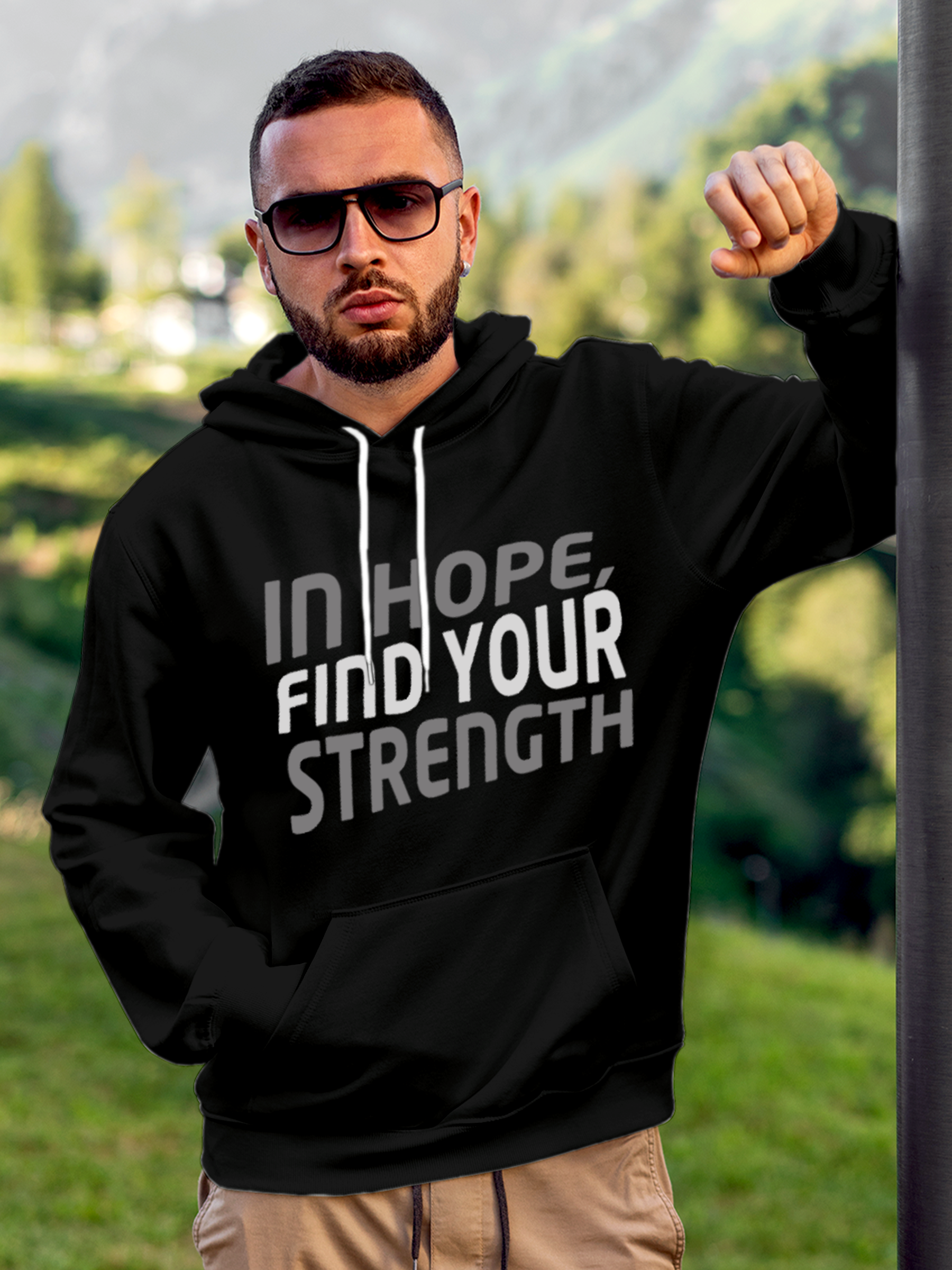 Model wearing Men's Black Hoodie Sweatshirt with 'In Hope, Find Your Strength' design, offering effortless style and premium comfort