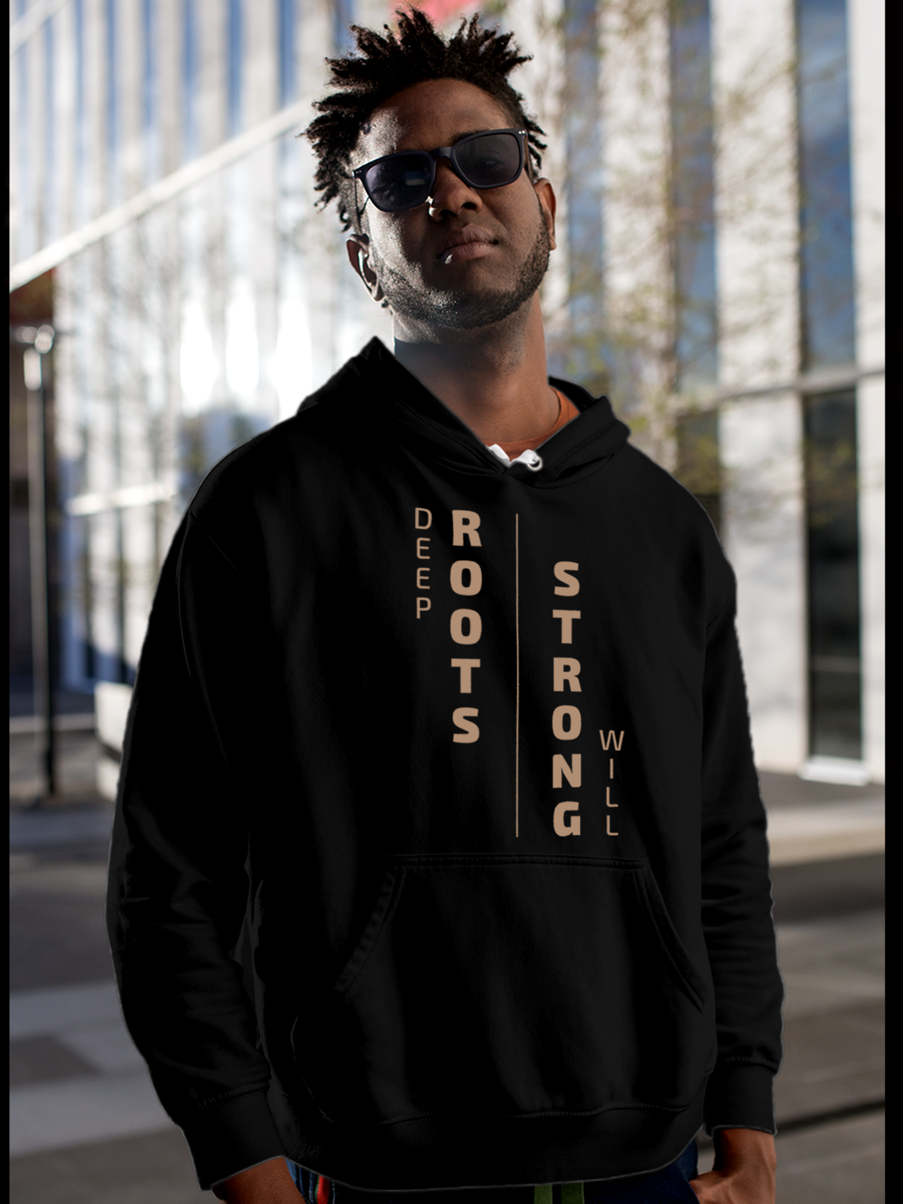 Model wearing Men's Black Hoodie Sweatshirt with 'Deep Roots Strong Will' design, offering effortless style and premium comfort