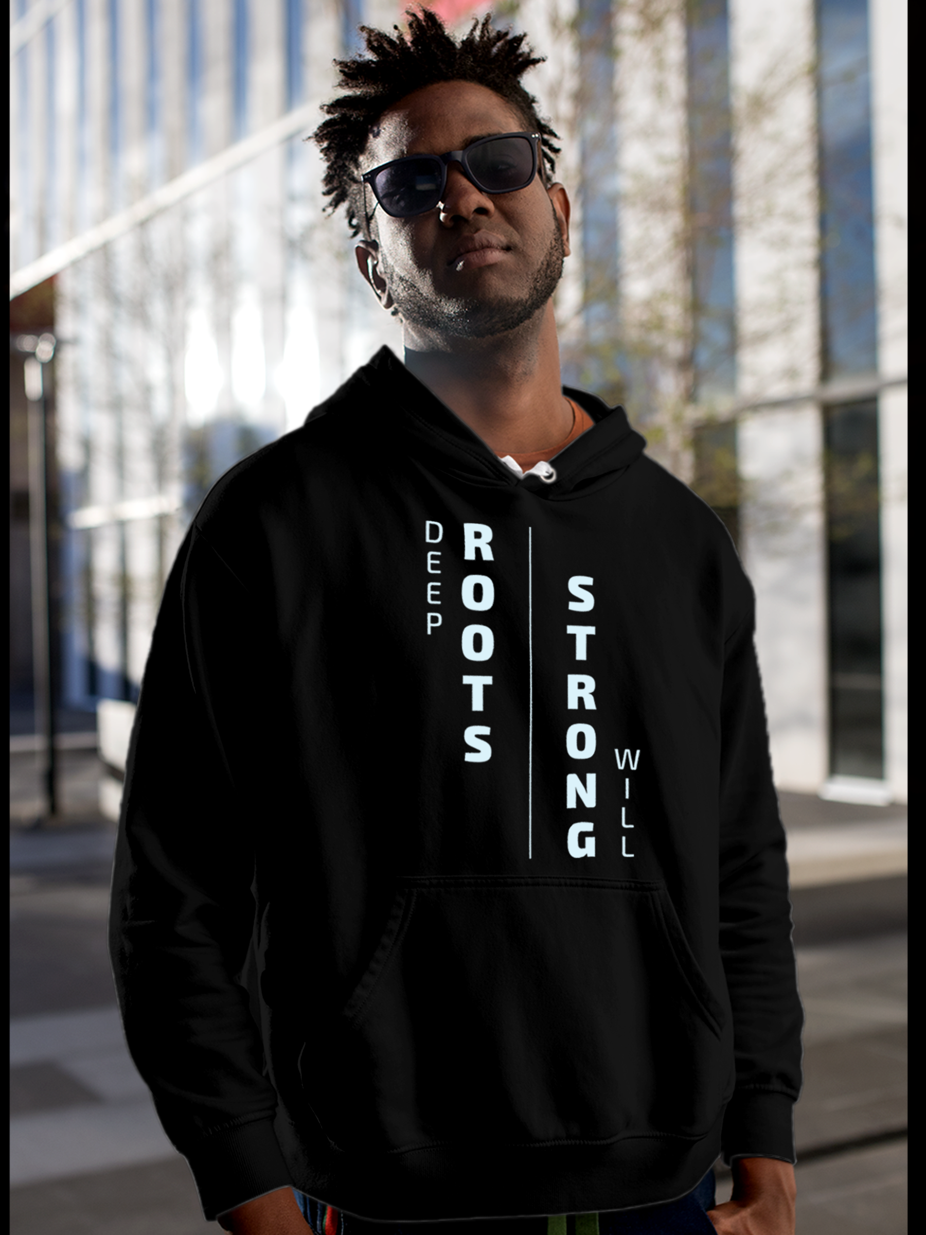 Model wearing Men's Black Hoodie Sweatshirt with 'Deep Roots Strong Will' design, offering effortless style and premium comfort