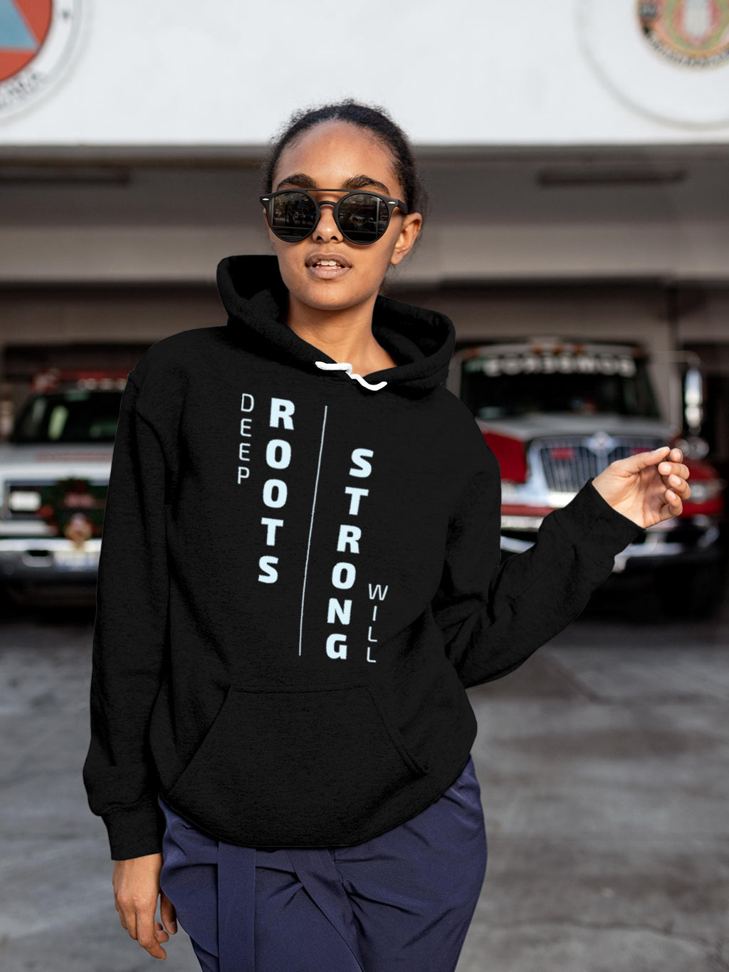Model wearing Women's Black Hoodie Sweatshirt with 'Deep Roots Strong Will' design, offering effortless style and premium comfort