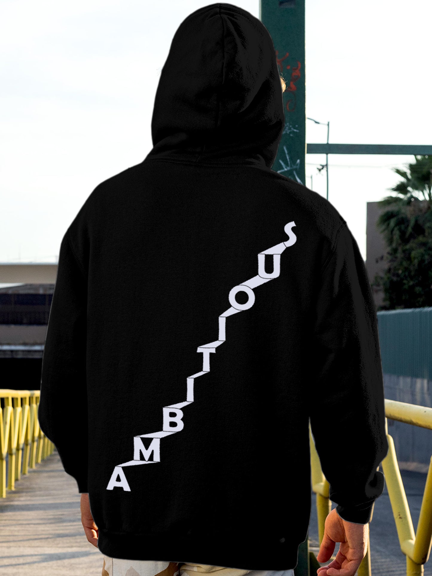 Model wearing Men's Black Hoodie Sweatshirt with 'Ambitious' design, offering effortless style and premium comfort