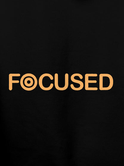 Close up of 'Focused' design on Women's Black Hoodie Sweatshirt, highlighting intricate details and vibrant print.