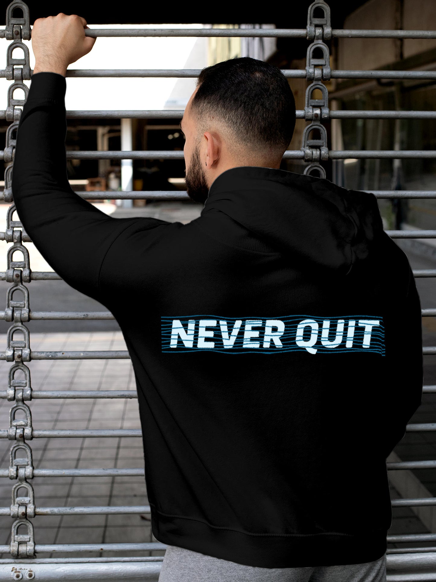 Model wearing Men's Black Hoodie Sweatshirt with 'Never Quit' design, offering effortless style and premium comfort