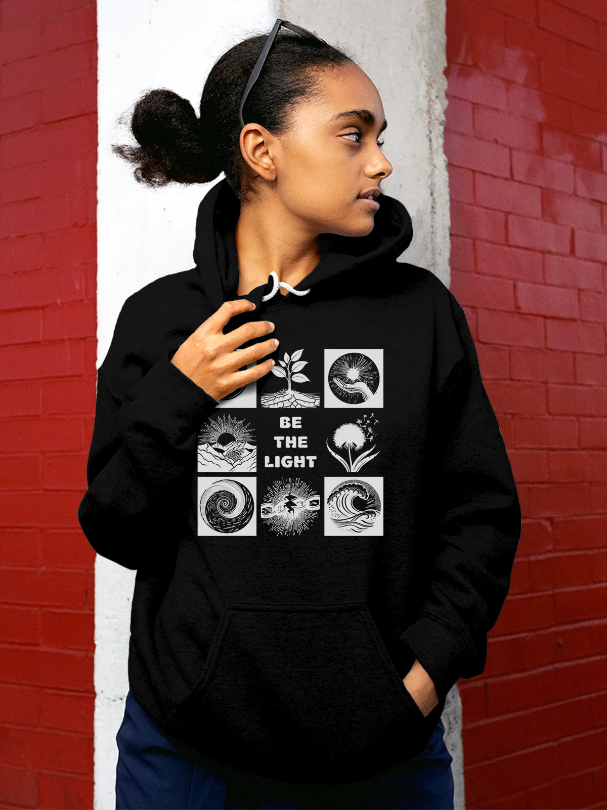 Model wearing Women's Black Hoodie Sweatshirt with 'Be The Light' design, offering effortless style and premium comfort
