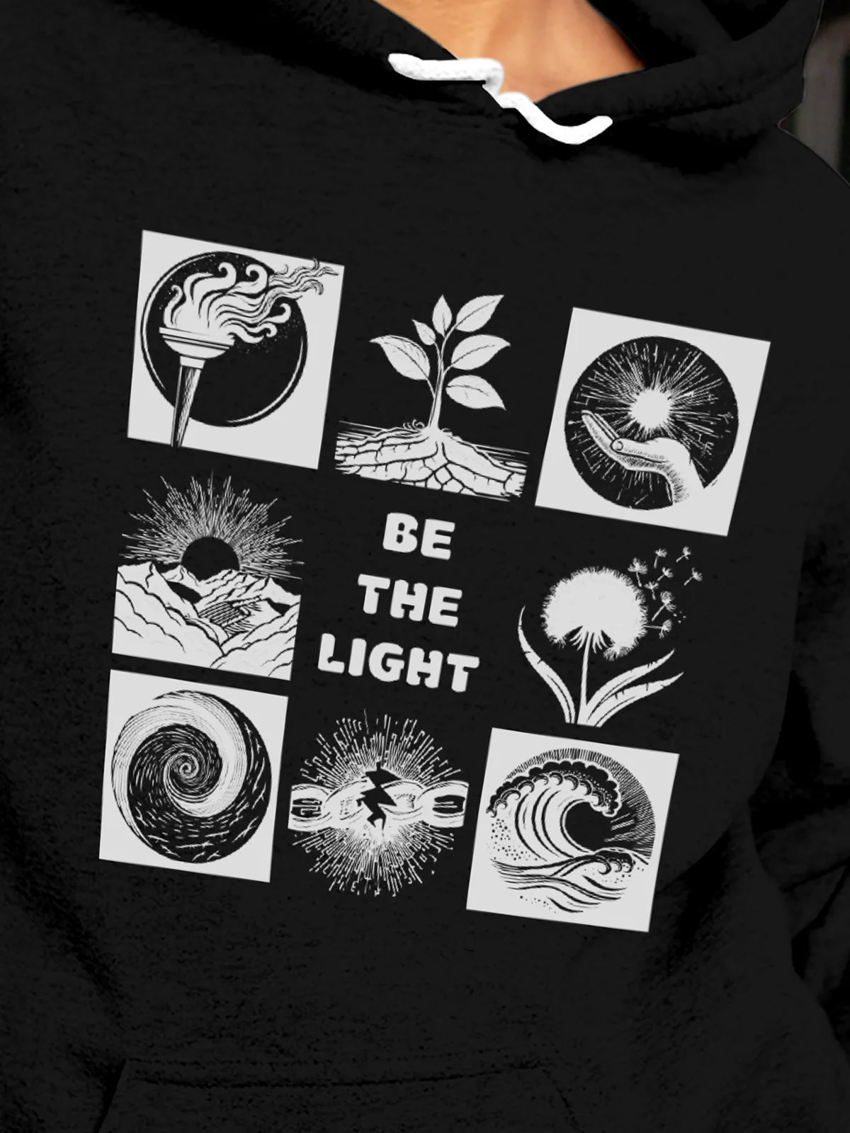 Close up of 'Be The Light' design on Women's Black Hoodie Sweatshirt, highlighting intricate details and vibrant print.
