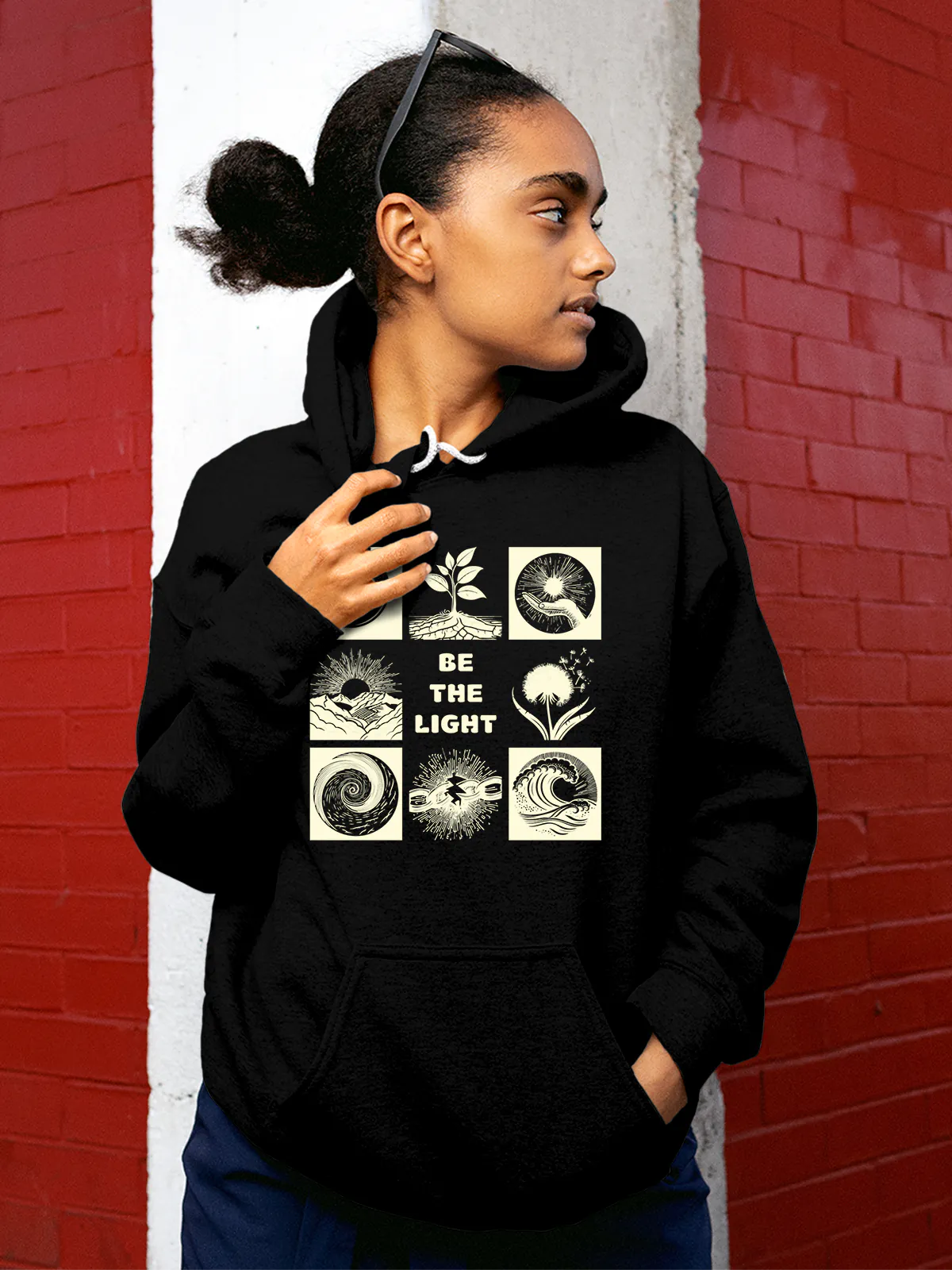 Model wearing Women's Black Hoodie Sweatshirt with 'Be The Light' design, offering effortless style and premium comfort