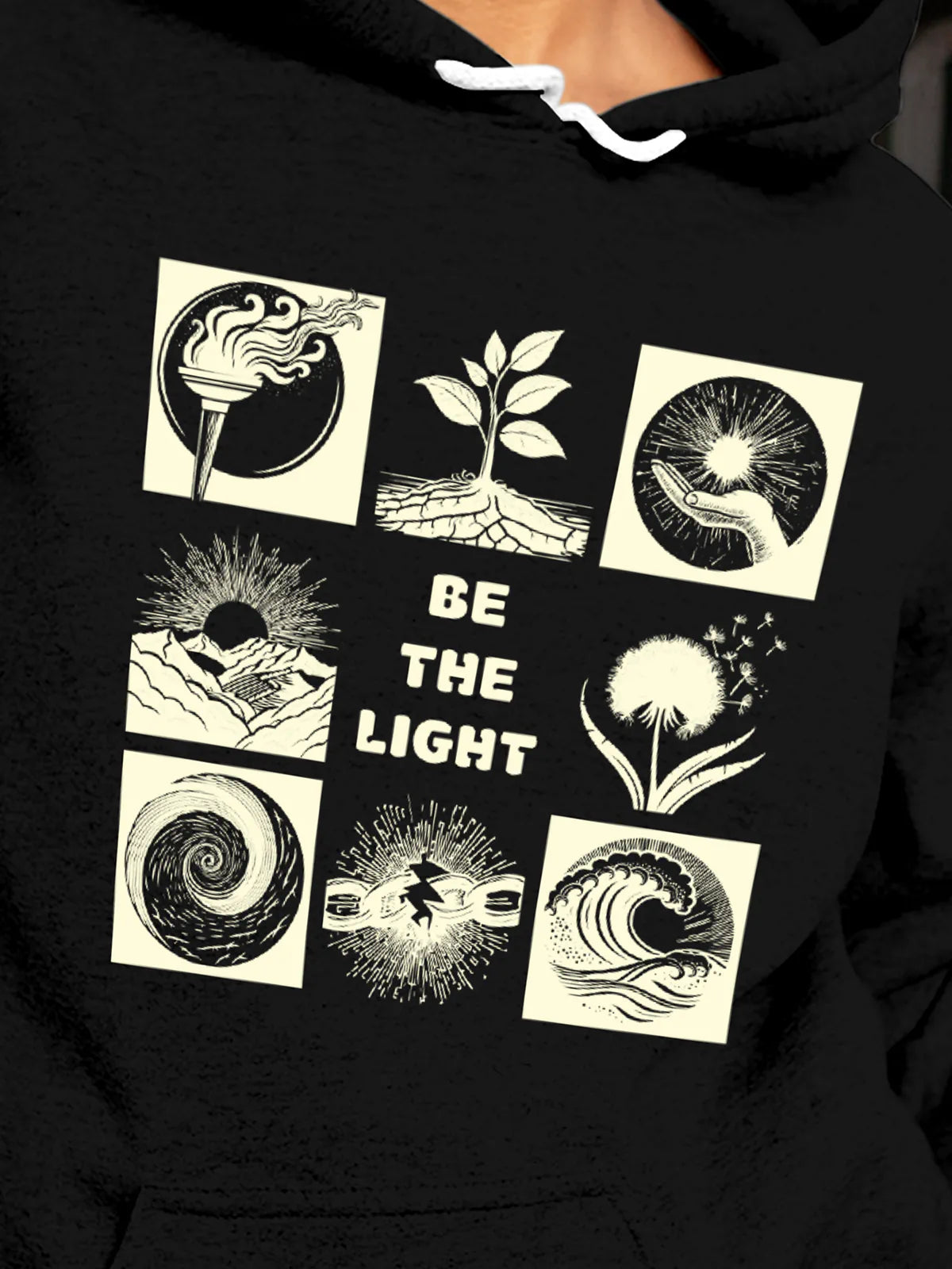 Close up of 'Be The Light' design on Women's Black Hoodie Sweatshirt, highlighting intricate details and vibrant print.