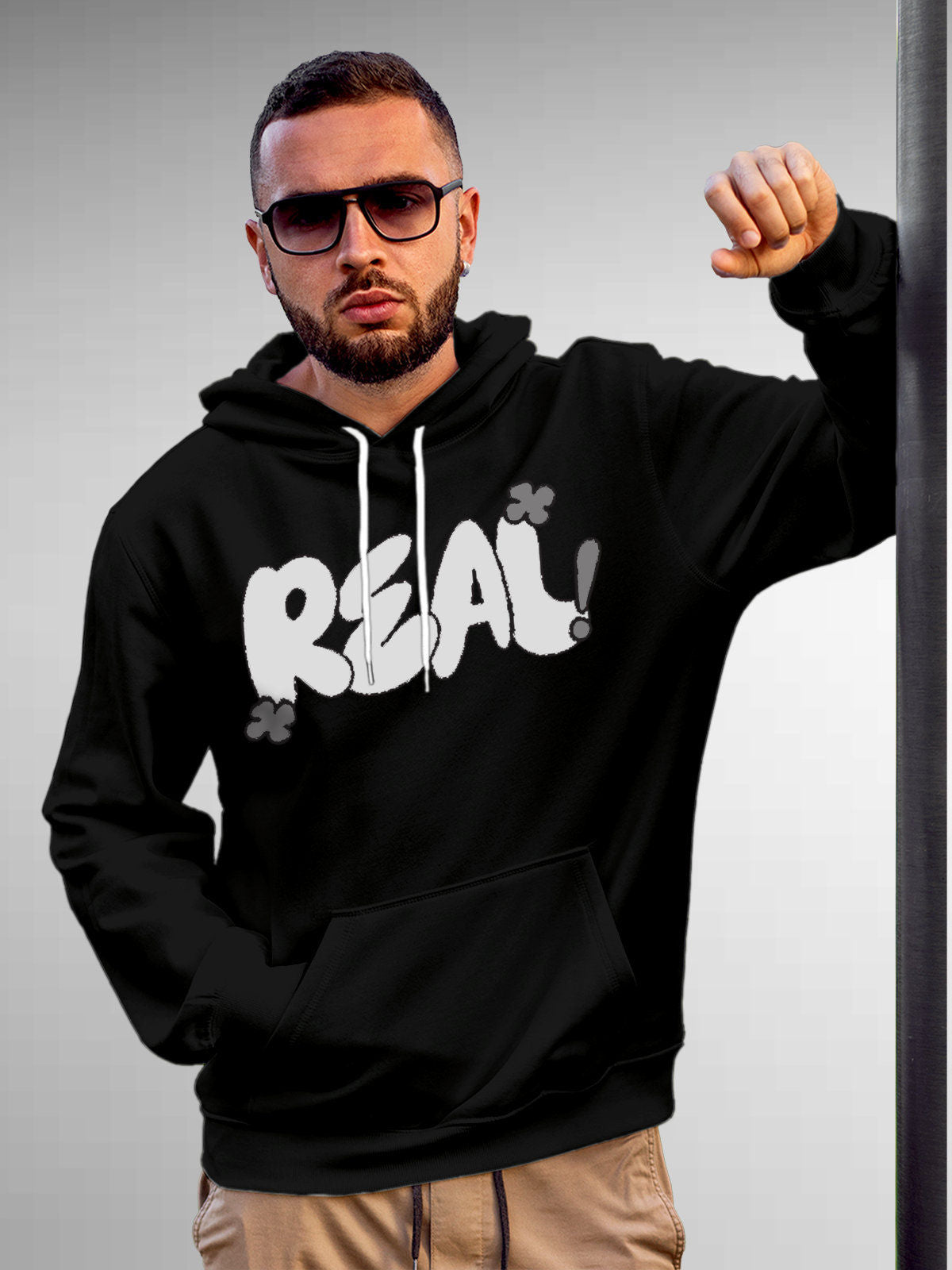 Model wearing Men's Black Hoodie Sweatshirt with 'Real' design, offering effortless style and premium comfort
