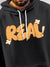 Close up of 'Real' design on Men's Dark Grey Hoodie Sweatshirt, highlighting intricate details and vibrant print.