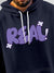 Close up of 'Real' design on Men's Navy Blue Hoodie Sweatshirt, highlighting intricate details and vibrant print.