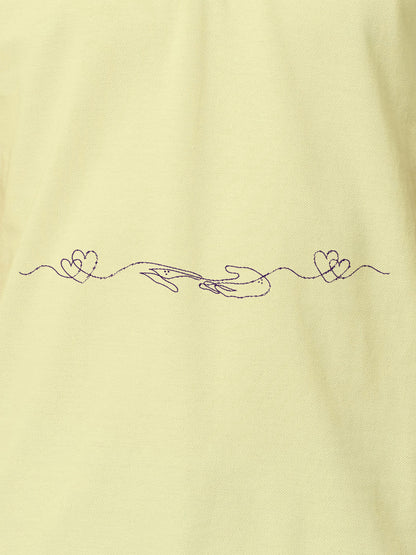 Close up of 'Empathy' design on Women's Yellow Polo T-shirt, highlighting intricate details and vibrant print.