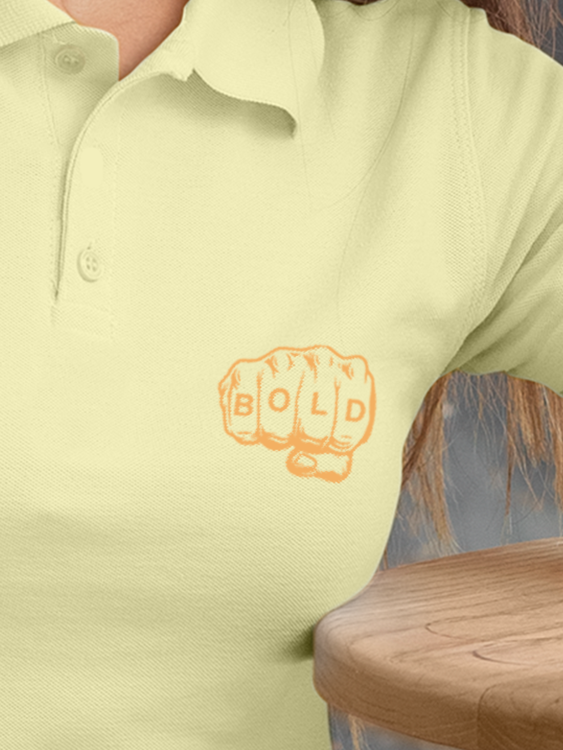 Close up of 'Bold' design on Women's Yellow Polo T-shirt, highlighting intricate details and vibrant print.