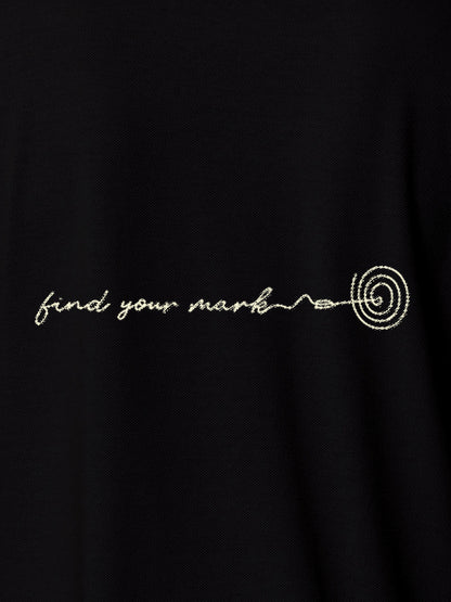 Close up of 'Find Your Mark' design on Women's Black Polo T-shirt, highlighting intricate details and vibrant print.