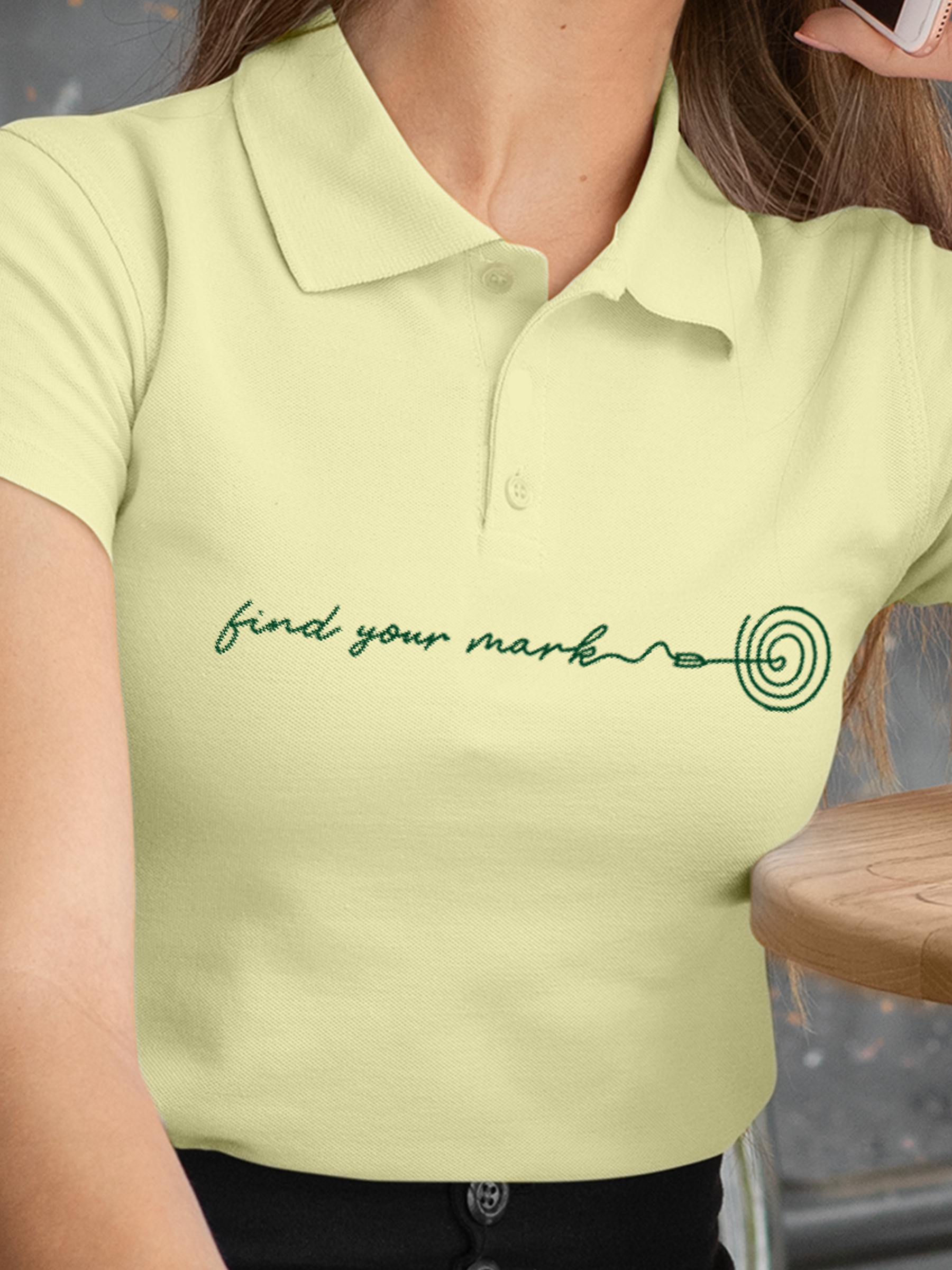 Close up of 'Find Your Mark' design on Women's Yellow Polo T-shirt, highlighting intricate details and vibrant print.