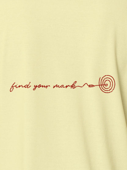 Close up of 'Find Your Mark' design on Women's Yellow Polo T-shirt, highlighting intricate details and vibrant print.