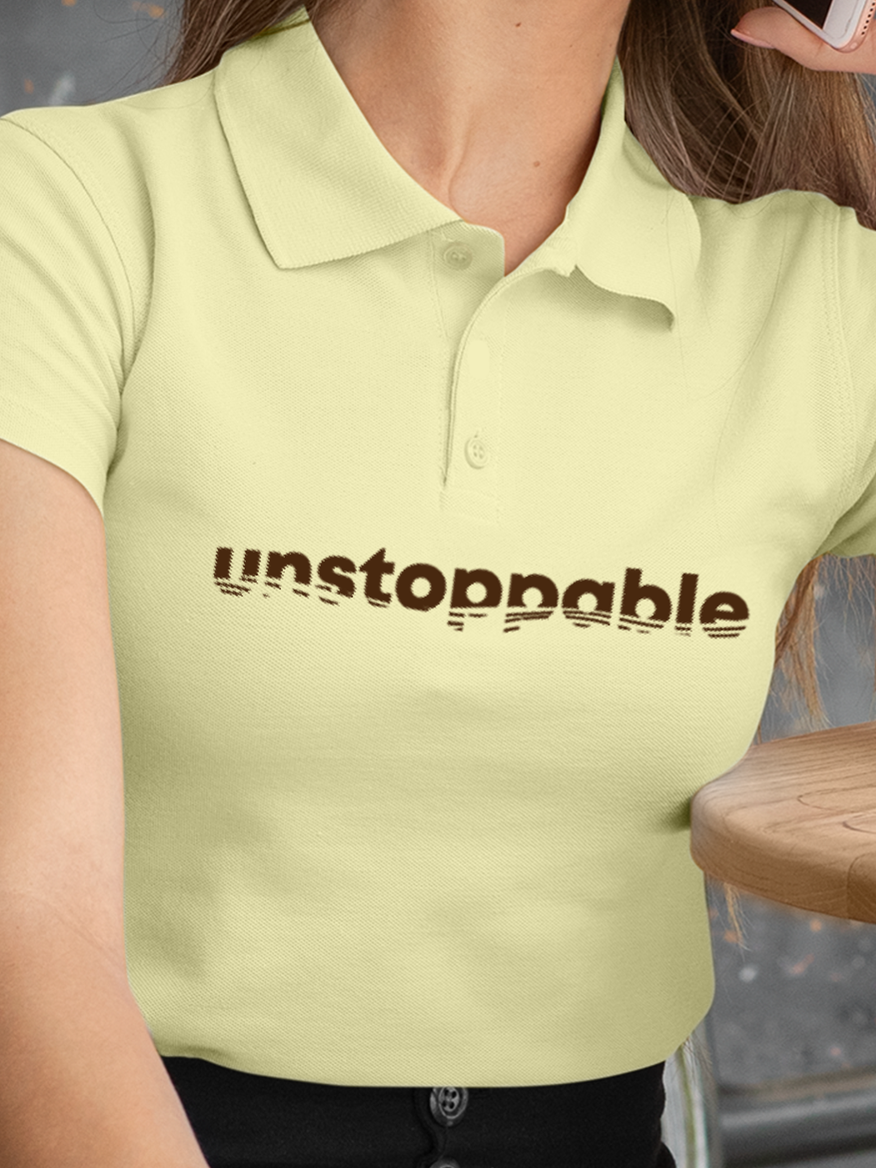 Close up of 'Unstoppable' design on Women's Yellow Polo T-shirt, highlighting intricate details and vibrant print.
