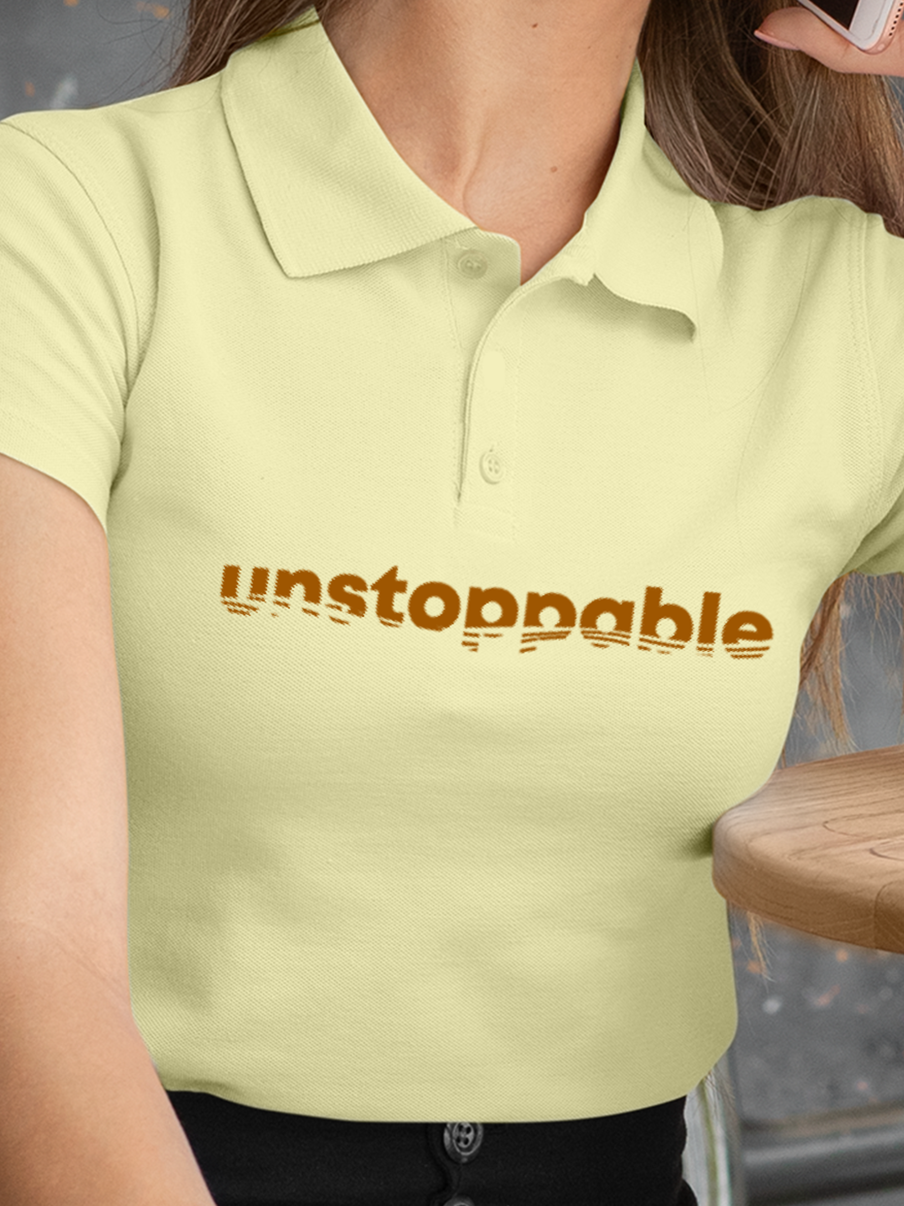 Close up of 'Unstoppable' design on Women's Yellow Polo T-shirt, highlighting intricate details and vibrant print.